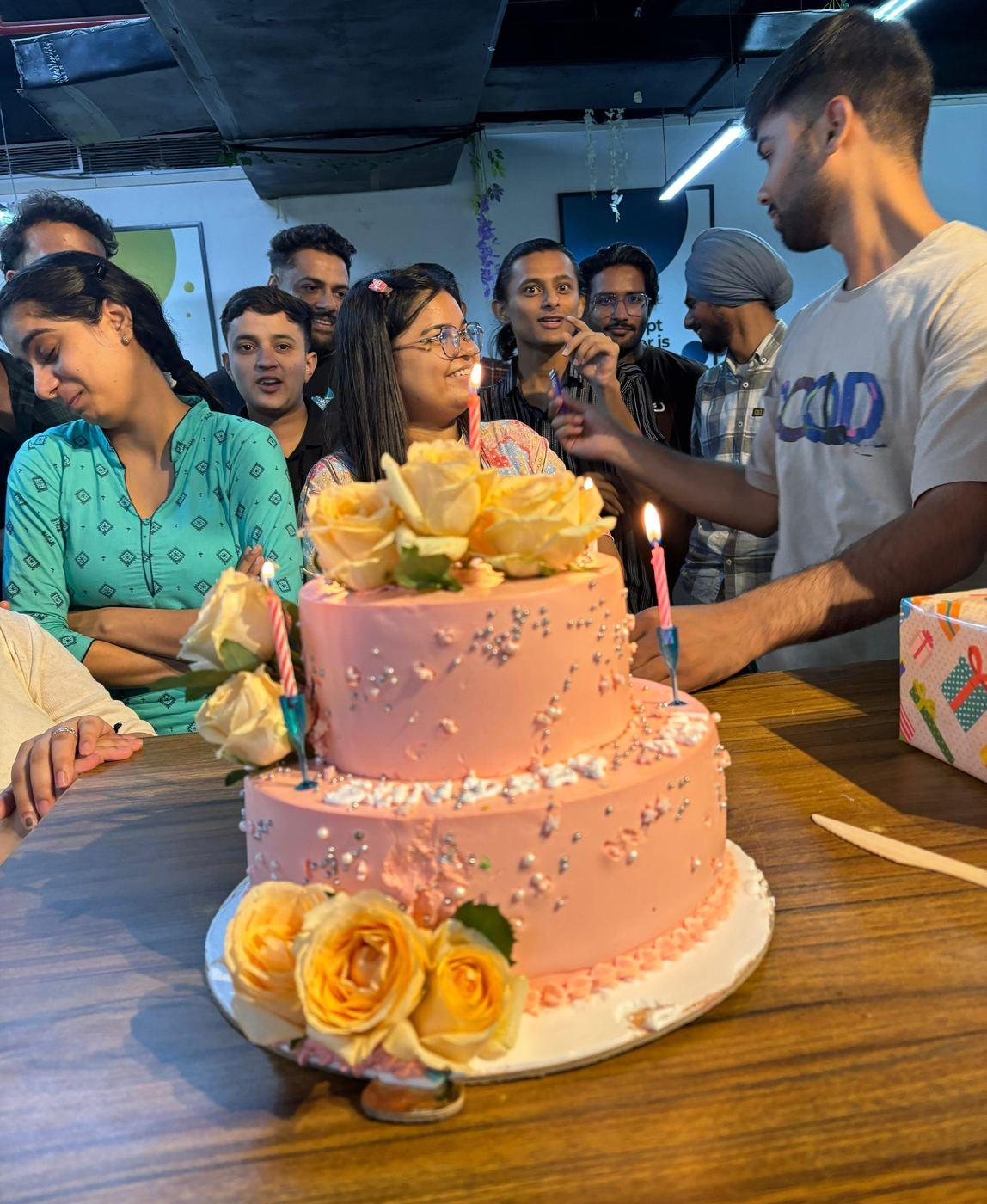 Team gathered around a birthday cake in the office